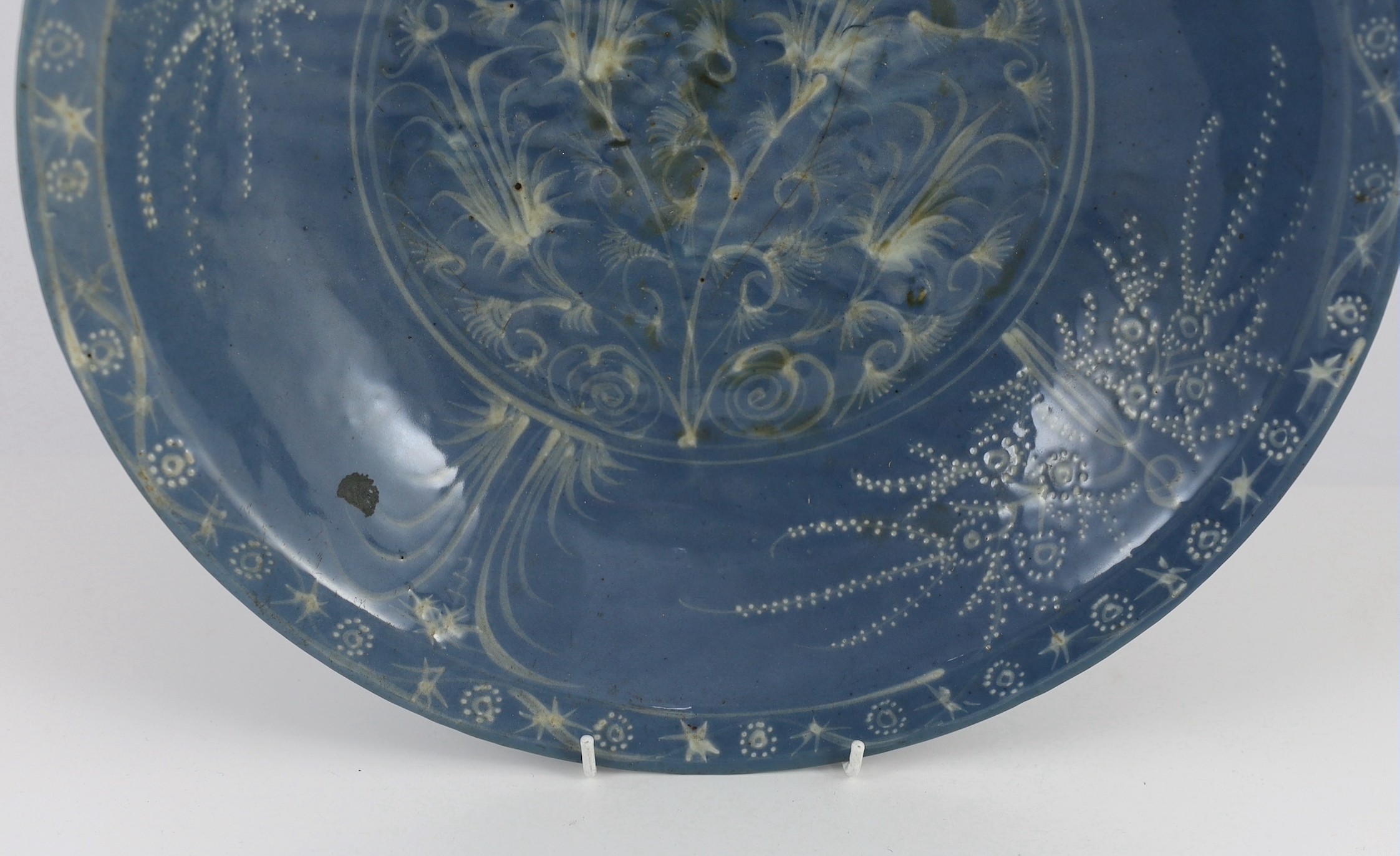 A Chinese Swatow slip-decorated blue glazed deep dish, Zhangzhou kilns, early 17th century, 38cm wide, crack to base